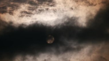 4K 60p Yakın çekim Fırtınalı Hava Bulutları Güneş Günbatımını örter. Koyu Gri Bulutlar Hızlı Hareket Ediyor. Yuvarlak Güneş Diski. Şiddetli Rüzgar İklimi Akşam Havası