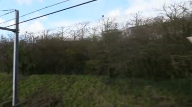 Paris Suburban Demiryolu ile seyahat. RER Tren Penceresinden Demiryolu 'na doğru ilerliyoruz. Ile-de-France. Paris, Fransa, Avrupa. 2x Yavaş çekim 60 fps 4K