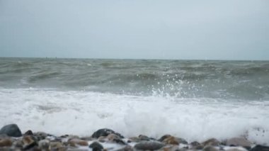 Fırtınalı Deniz. Taşlı Sahil. Dalgalar Pebble Sahili 'ne çarpıyor. Atlantik Okyanusu. Gri Bulutlu Gökyüzü. İngiliz kanalı. Le Havre Normandiya Fransa Avrupa. 2x Yavaş çekim 60 fps 4K