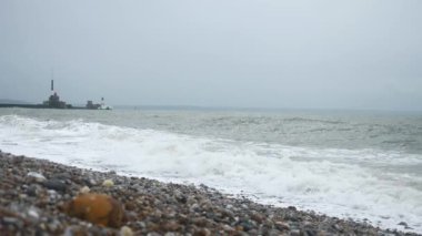 Fırtınalı Deniz. Taşlı Sahil. Dalgalar Pebble Sahili 'ne çarpıyor. Atlantik Okyanusu. Gri Bulutlu Gökyüzü. İngiliz kanalı. Le Havre Normandiya Fransa Avrupa. 2x Yavaş çekim 60 fps 4K