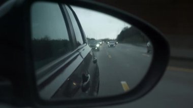 Araba Tarafı Ayna Kanadı 'na yakın çekim yağmur damlaları. Otoyol boyunca taşıt ile seyahat ederek ülkeyi boydan boya geçerek. Yağmurlu hava. Fransa Avrupa. 2x Yavaş çekim 60 fps 4K