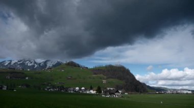 Picturesque Green Valley 'de bir kasaba. Dağların yakınında. Arabanın penceresinden yan görüş. İsviçre Avrupa. 2020 baharında. Yavaş çekim