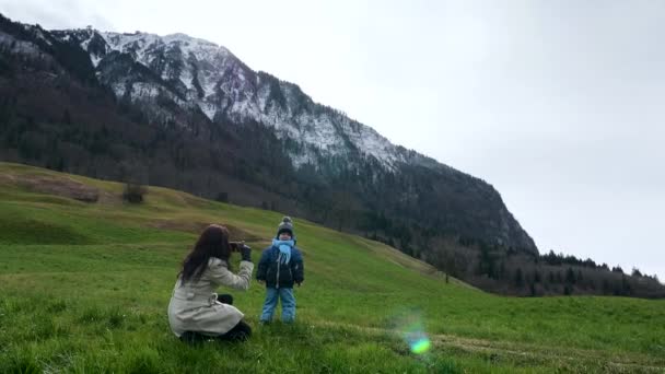 Matka Fotí Fotky Smartphone Malého Dítěte Trávě Blízkosti Scenic Mountain — Stock video
