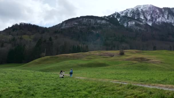 Matka Fotí Fotky Smartphone Malého Dítěte Trávě Blízkosti Scenic Mountain — Stock video