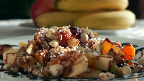 Kokosflingor Faller Fruktsallad Efterrätt Bananer Apelsin Kiwi Äpple Frukter Tallrik — Stockvideo