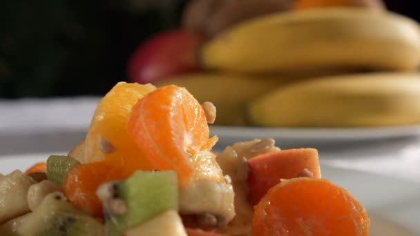Focus Pull Raw Fruit Salad Dessert to Bananas Orange Kiwi Apple Fruits on Plate Dish on Table in Kitchen Dining Room. 2x Slow motion 60fps 4K