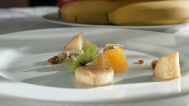 Fallende Obstsalatbestandteile Stücke Von Kiwi Orange Bananenkernen Rosinen Erdnüsse Auf — Stockvideo