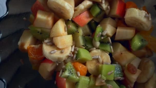 Close Spoon Mixes Fruit Salad Kiwi Orange Banana Apple Seeds — Stock Video