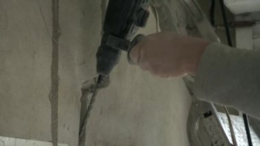 Professional Male Contractor Electrician Worker Drills Perforates Wall to Install Electrical Equipment Cables.  Man Uses Rotary Hammer Drill Perforator. 2x Slow motion 60fps 4K