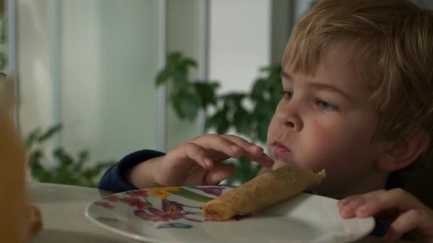 Carino Bambino Mangia Frittelle Arrotolato Con Riempimento Cibo Pasto Sul — Video Stock