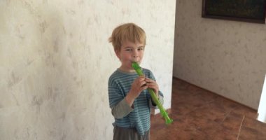 Şirin küçük çocuk flüt çalmaya çalışıyor. Mutlu Neşeli Sevimli Çocuk Gülümse 4K