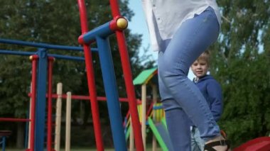 Çocuk parkında beden eğitimi yapan genç ve güzel bir kadın. Güzel Kadın Vücut Çalışması. Sabah Baharı Güneşli Günü. 2x Yavaş çekim 60fps 4K