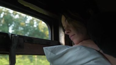 Old Vintage Train 'den Kadın Seyahati 3. sınıf Platzkart Car. Üst ranzada uzanan kadın turist Pencere İzleyen Doğa 'ya bakıyor. 2x Yavaş çekim 60fps 4K