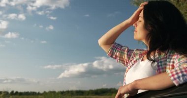 Kadın Sürücü Dinlenme Aracı 'nın yanında dinleniyor. Esmer Kadın Doğa Özgürlüğünün Taze Havası 'nın tadını çıkarıyor. Rüzgâr Esintisi Dalgalanan Saç. Yaz güneşli akşam 4K