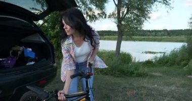 Anne, Çocuk Doğa Üzerine Araba 'nın yanında olduğu için rahat ol. Aile Tatil Pikniği River yakınlarında. Yaz güneşli 4K Günü