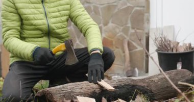 Man, arka bahçede baltayla odun kesiyor. Ağır çekim. 60 fp 10-bit.