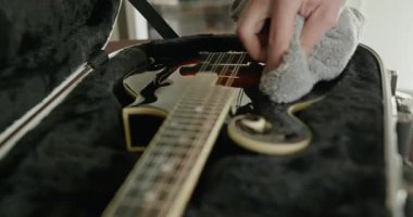 Erkek müzisyen özenle enli bir şekilde enstrümanla ilgileniyor. Mandolin 4K 10-bit 'ten Toz Temizle