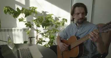 Bilgisayarı kullanarak Müzisyen Öğretmen Gitar Dersi Veriyor. 4K 10-bit