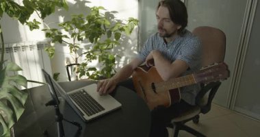 Bilgisayarı kullanarak Müzisyen Öğretmen Gitar Dersi Veriyor. 4K 10-bit