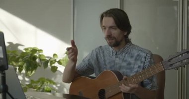 Bilgisayarı kullanarak Müzisyen Öğretmen Gitar Dersi Veriyor. 4K 10-bit