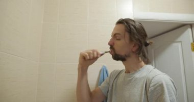 Adam yüzünü yıkar, dişlerini fırçalar banyoda 4K 10-bit