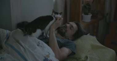 Adam Smartphone ve Kitten ile yatakta uyanıyor. 4K 10-bit