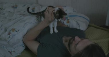 Adam Smartphone ve Kitten ile yatakta uyanıyor. 4K 10-bit