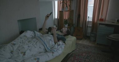 Adam Smartphone ve Kitten ile yatakta uyanıyor. 4K 10-bit