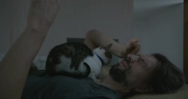 Adam Smartphone ve Kitten ile yatakta uyanıyor. 4K 10-bit