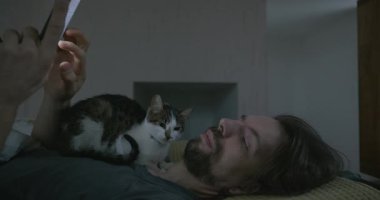 Adam Smartphone ve Kitten ile yatakta uyanıyor. 4K 10-bit