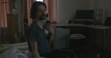 Adam Smartphone ve Kitten ile yatakta uyanıyor. 4K 10-bit