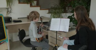 Erkek Öğretmen Bir Çocuğa Müzik Dersi Veriyor. Adam Çocuğa Müzik Enstrümanı çalmayı öğretiyor. 4K 10-bit