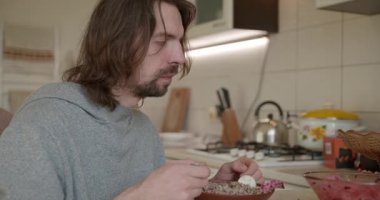 Adam salata ve karabuğday lapası yiyor Kahvaltı için 4K 10-bit