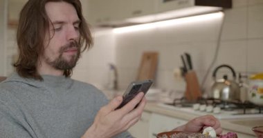 Adam salata ve karabuğday lapası yiyor Kahvaltı için 4K 10-bit