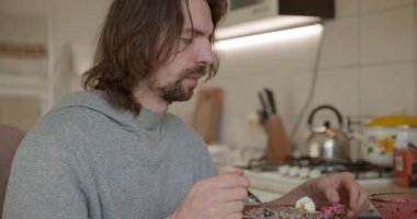 Adam salata ve karabuğday lapası yiyor Kahvaltı için 4K 10-bit