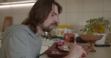 Adam salata ve karabuğday lapası yiyor Kahvaltı için 4K 10-bit