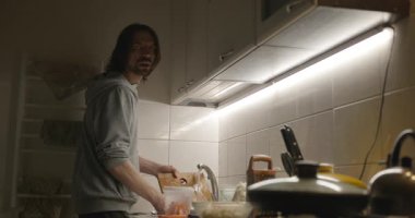 Adam omleti hazırlar, akşam yemeği için salata karabuğday lapası. 4K 10-bit