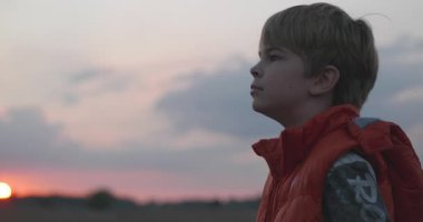 Çocuk doğayı seviyor. Kid Watch Sunset Sky sahada. 4K 10-bit