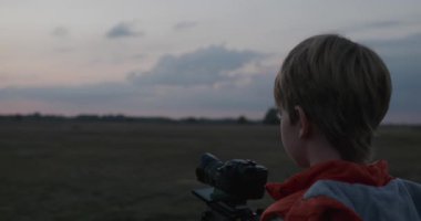 Tripod 'da Mirorless Camera ile Doğayı Çeken Çocuk. 4K 10-bit