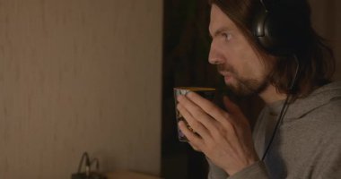 Man, Akşam Bilgisayar 'da Çay İçen Video İzliyor. 4K 10-bit