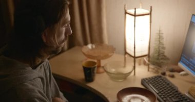 Man, Akşam Bilgisayar 'da Çay İçen Video İzliyor. 4K 10-bit