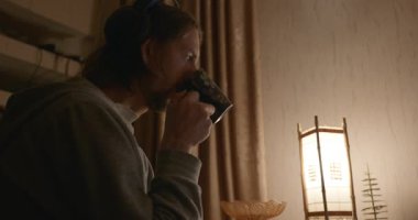 Man, Akşam Bilgisayar 'da Çay İçen Video İzliyor. 4K 10-bit