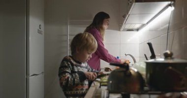İnsan ve Çocuk Aile Yemeği ya da Akşam Yemeği Mutfağında Yemek Hazırlayın. 4K 10-bit