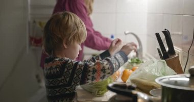 İnsan ve Çocuk Aile Yemeği ya da Akşam Yemeği Mutfağında Yemek Hazırlayın. 4K 10-bit