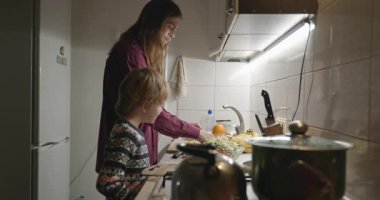 İnsan ve Çocuk Aile Yemeği ya da Akşam Yemeği Mutfağında Yemek Hazırlayın. 4K 10-bit