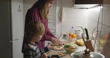 İnsan ve Çocuk Aile Yemeği ya da Akşam Yemeği Mutfağında Yemek Hazırlayın. 4K 10-bit