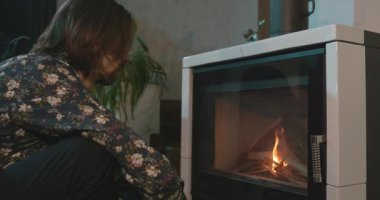 Adam evdeki şöminede ateş yakıyor. 4K 10-bit