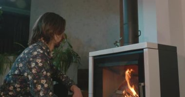 Adam evdeki şöminede ateş yakıyor. 4K 10-bit