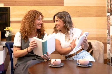 İki arkadaş ellerinde kitap tutarken ve kahve içerken animasyon sohbeti yapıyorlar.