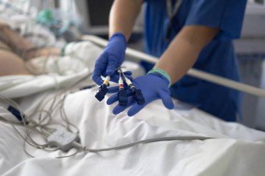 Hastanedeki hasta ekokardiyogramı için tıbbi elektrotlar tutan sağlık uzmanı